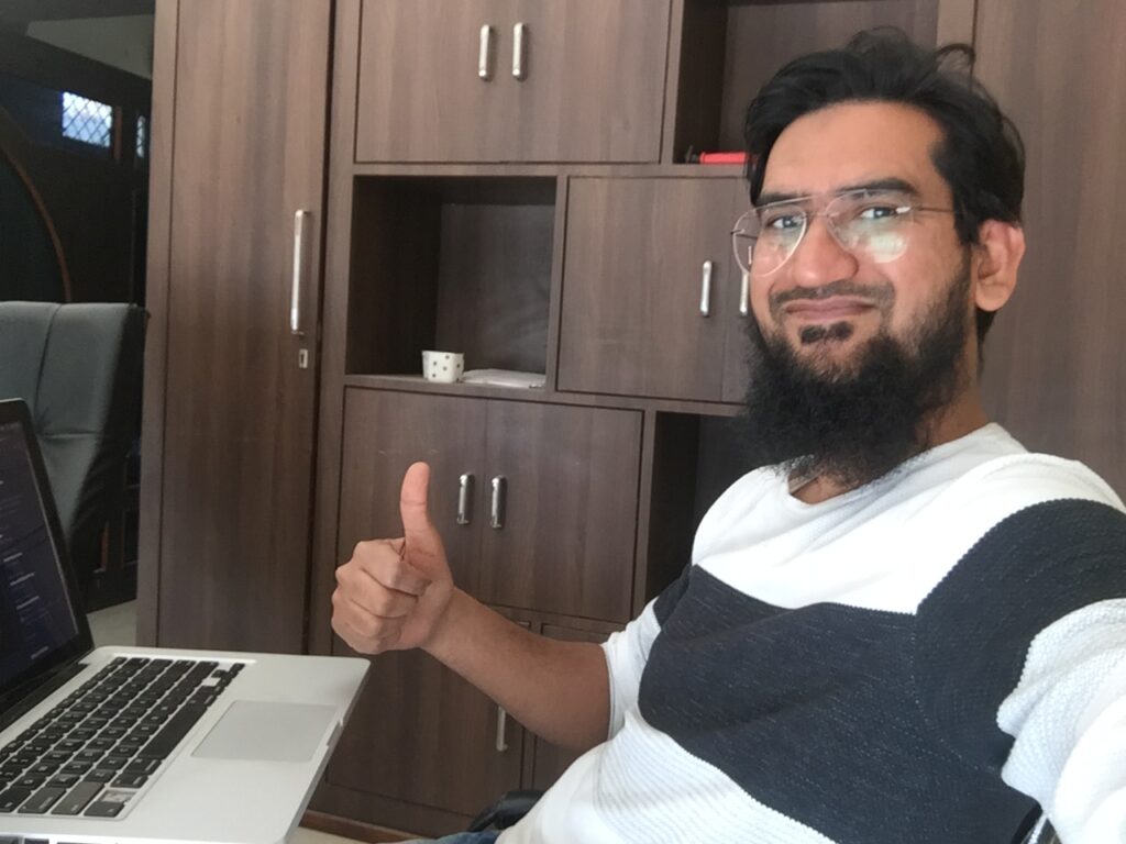 Mohammed Asif sitting in his office thumbs up asifindia